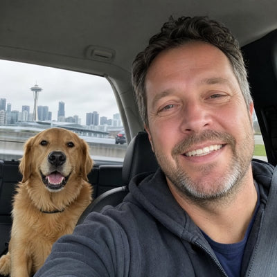David K. in the car with Duke, his Golden Retriever in a black CollarZen collar